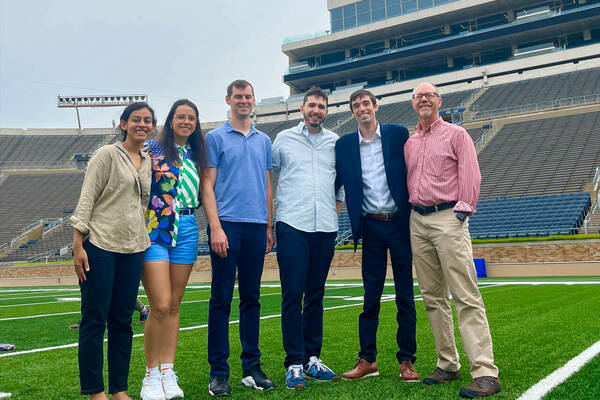 2023's 6 new faculty members standing on the football field. From left to right: Niharika Singh, Victoria Barone, Jeff Denning, Heitor Pellegrina, Chris Mills, Jeff Biddle.