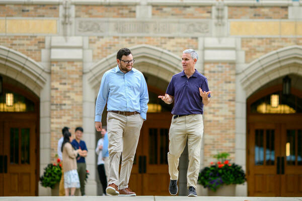 Professor James Sullivan walks outside with his student.