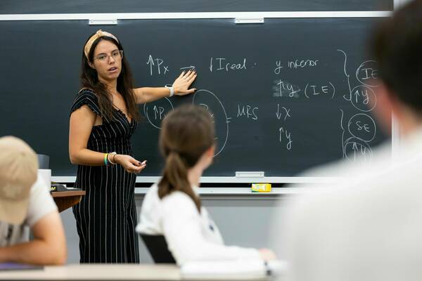 Assistant Professor Victoria Barone references a chalkboard for her class