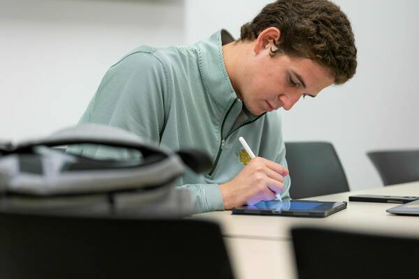 A student takes notes on his iPad